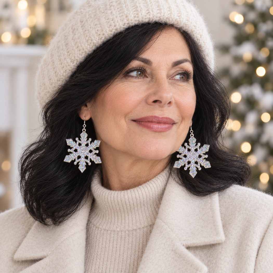 Silver glitter acrylic snowflake statement earrings worn with a cream winter outfit