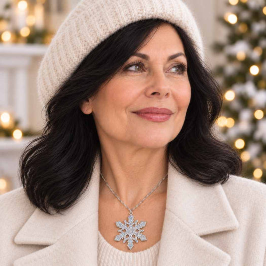 Silver glitter acrylic snowflake necklace on a delicate silver-tone chain worn with a cream winter outfit